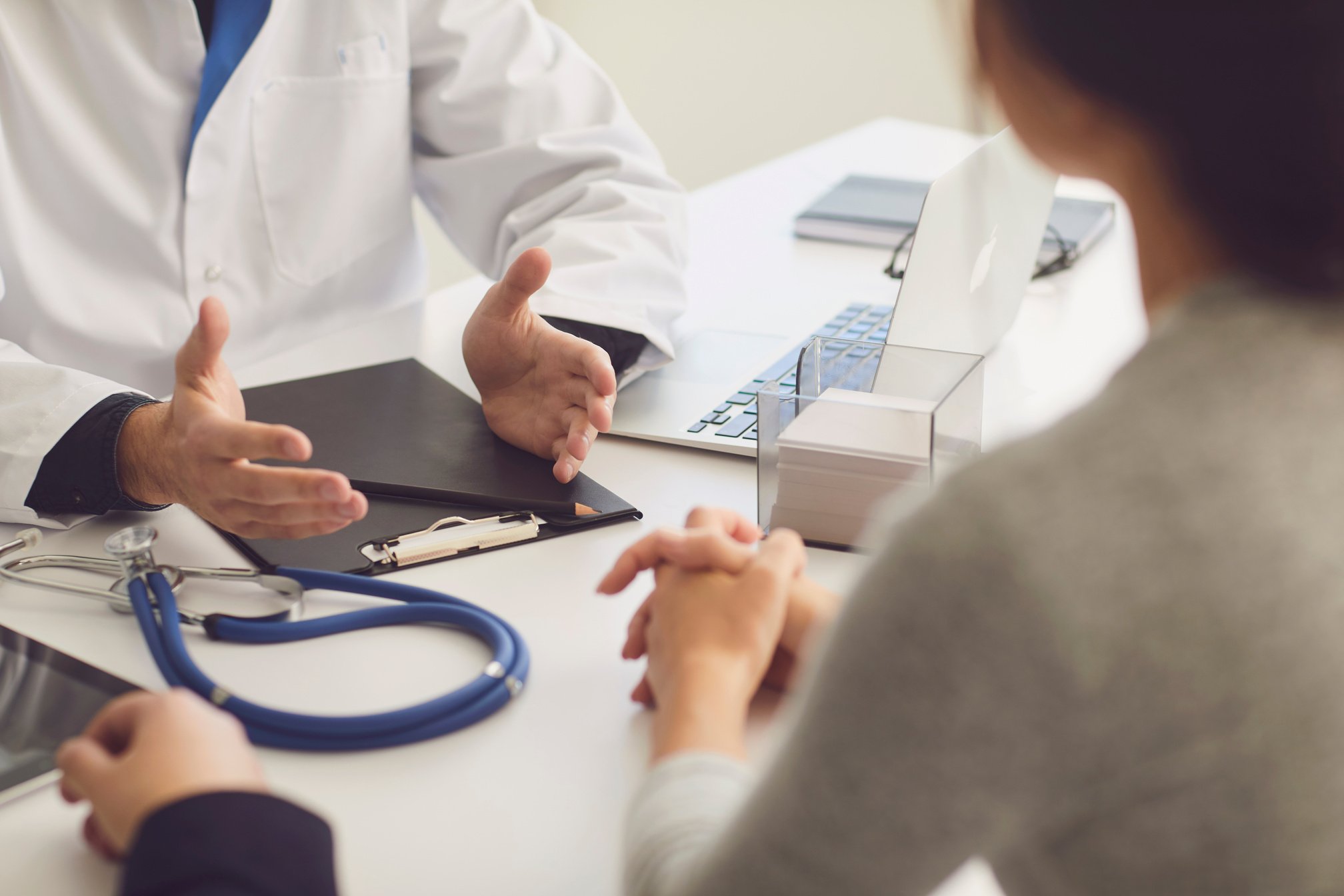 Confident Doctor and Couple Patient Sitting at the Table in Clinic Office. Family Doctor.